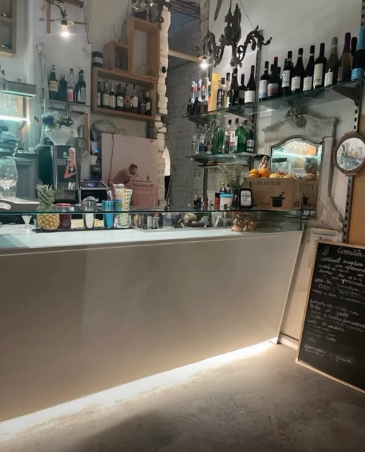 Il bancone retroilluminato con bottiglie e lampadari vintage