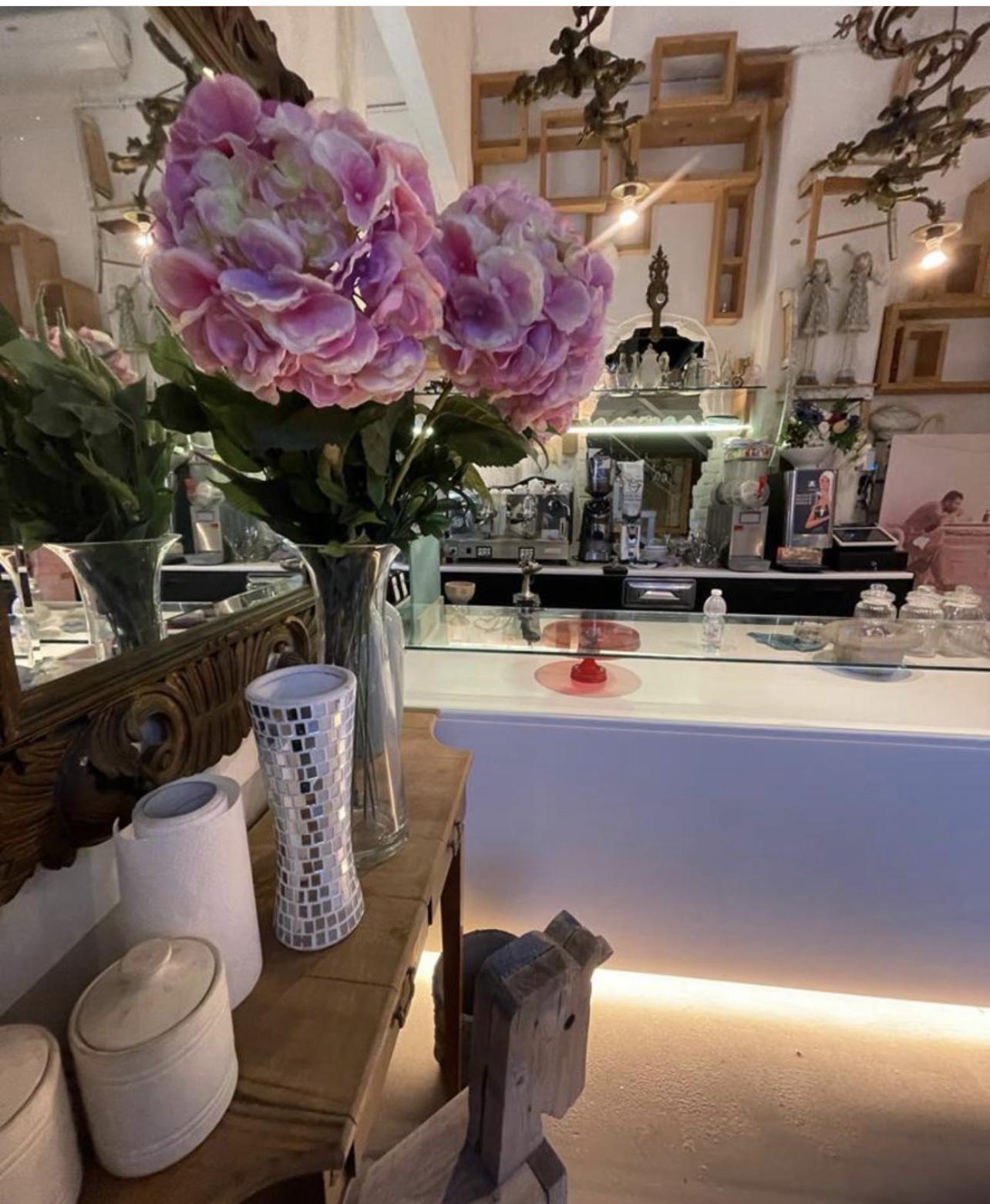 Angolo con fiori, specchi e ceramiche vicino al bancone